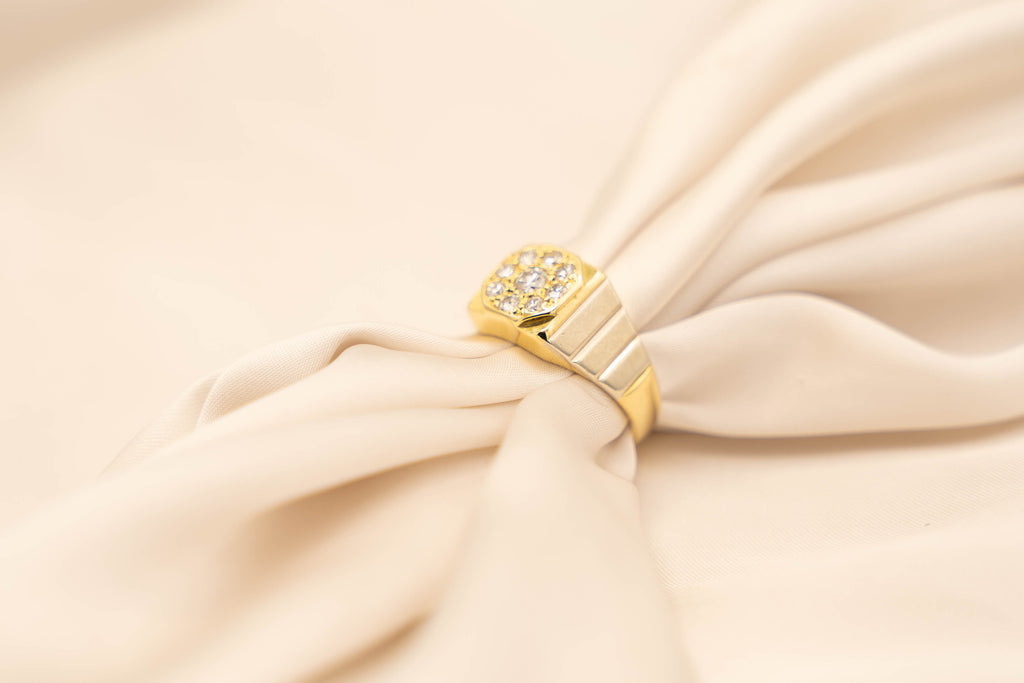 Goud: 18 karaat geelgoud & witgoud
Totaal gewicht: 8 gram
Ringmaat: 17,5
Steensoort: 9 x diamant waarvan de middensteen groter is dan de buitensteentjes
Slijpvorm: Briljant
Diamantgewicht: ± 0.46 crt totaal
Kleur diamant: Wesselton
Kwaliteit: SI

Vervangingswaarde:€ 2750,-